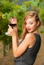 Attractive stylish woman drinking glass of red wine in vineyard Royalty Free Stock Photo