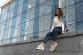 Attractive stylish woman resting on city street. Young woman in sunglesses in youth clothing on the city street Royalty Free Stock Photo