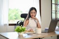 Attractive Asian businesswoman reading a book, working at her desk in the office Royalty Free Stock Photo