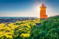 Attractive summer view of Stafnesviti lighthouse among the field of blooming flowers.