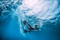 Attractive surfer girl dive underwater with wave