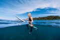 Attractive surfer girl at surfboard in ocean, Bali