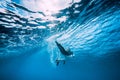 Attractive surfer woman dive underwater with under wave in ocean