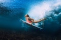 Attractive surfer woman dive underwater with under wave.