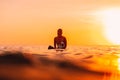 Attractive surfer woman on a surfboard in ocean. Surfgirl at sunset