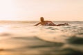 Attractive surfer woman on a surfboard in ocean. Surfgirl at sunset Royalty Free Stock Photo