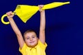 Attractive surprised caucasian blond schoolboy Shows unexpanded umbrella Royalty Free Stock Photo