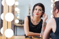 Attractive tattooed woman doing makeup in dressing room Royalty Free Stock Photo