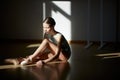 Attractive teen girl, classical ballet dancer getting ready to dance in ballet school on a daytime with sunlight Royalty Free Stock Photo