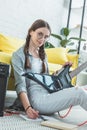 attractive teen girl with electric guitar writing song in copybook while sitting Royalty Free Stock Photo