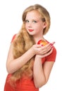 Attractive teen girl in the orange t-shirt holding an red apple Royalty Free Stock Photo