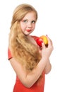 Attractive teen girl in the orange t-shirt holding an red apple Royalty Free Stock Photo