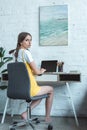 attractive teen girl using laptop and sitting at table Royalty Free Stock Photo