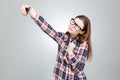 Attractive teenage girl in glasses using smartphone and taking selfie Royalty Free Stock Photo