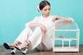 attractive teenager in white outfit with parrot in cage Royalty Free Stock Photo