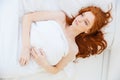Attractive tender woman with long red hair lying in bed Royalty Free Stock Photo