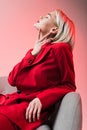 attractive tender woman in red clothes posing in armchair, Royalty Free Stock Photo