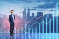Attractive thoughtful european businessman standing on toned city background with forex chart. Finance, trade and CEO concept.