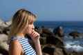 Attractive thoughtful girl rocky beach by the sea.