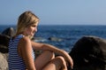 Attractive thoughtful girl rocky beach by the sea. Royalty Free Stock Photo