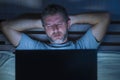 Attractive tired and stressed workaholic man working late night exhausted on bed busy with laptop computer sleepy and overworked Royalty Free Stock Photo