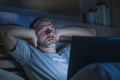 Attractive tired and stressed workaholic man working late night exhausted on bed busy with laptop computer sleepy and overworked Royalty Free Stock Photo
