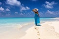 Woman in blue dress walks on a tropical beach Royalty Free Stock Photo