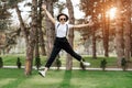 Attractive trendy happy hipster young woman in hat and sunglasses have fun in the park at the sunset. Freedom concept. Royalty Free Stock Photo