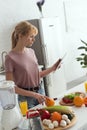 attractive vegan girl reading recipe for cooking on tablet