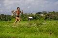 Attractive and very fit Asian sport woman training running workout at green field landscape background working hard in healthy lif Royalty Free Stock Photo