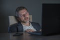 Attractive wasted and tired entrepreneur man working late night at office laptop computer desk exhausted and sleepy in financial Royalty Free Stock Photo