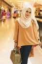 Attractive white hijab muslim woman in Shopping mall and holding a handbag.