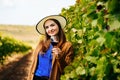 Attractive winemaker woman holding a glass of red wine in her hand and looking at the camera