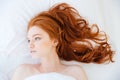 Attractive woman with beautiful long red hair lying in bed Royalty Free Stock Photo