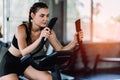 Attractive woman biking in the gym, exercising legs doing cardio workout cycling bikes. Royalty Free Stock Photo