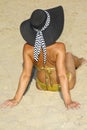 Attractive woman in a bikini on the beach, wearing a hat, photographed from behind Royalty Free Stock Photo