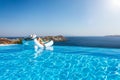 Woman floats on a infinity swimming pool with view to the Mediterranean sea in Greece Royalty Free Stock Photo