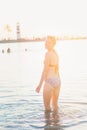 Attractive woman in bikini at the shore near lighthouse Royalty Free Stock Photo