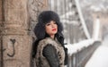 Attractive woman with black fur cap and gray waistcoat enjoying the winter. Side view of fashionable brunette girl posing Royalty Free Stock Photo