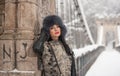 Attractive woman with black fur cap and gray waistcoat enjoying the winter. Side view of fashionable brunette girl posing Royalty Free Stock Photo