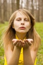 Attractive woman blowing kiss in nature