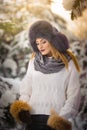 Attractive woman with brown fur cap and jacket enjoying the winter. Side view of fashionable blonde girl posing Royalty Free Stock Photo