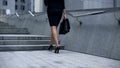 Attractive woman in business suit walking upstairs, concept of successful career