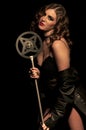 Attractive woman cabaret singer holding a 1920's microphone leaning to one side Royalty Free Stock Photo