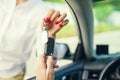 An attractive woman in a car gets the car keys. Rent or purchase of auto. Royalty Free Stock Photo