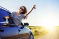 An attractive woman in a car holds a car key in her hand. Royalty Free Stock Photo