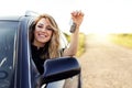 An attractive woman in a car holds a car key in her hand. Royalty Free Stock Photo