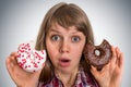 Attractive woman is choosing between two donuts Royalty Free Stock Photo