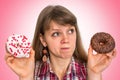 Attractive woman is choosing between two donuts Royalty Free Stock Photo