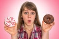 Attractive woman is choosing between two donuts Royalty Free Stock Photo